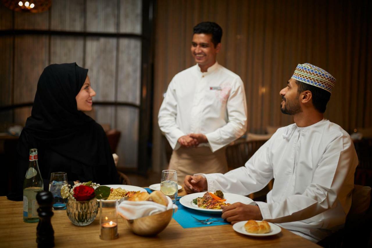 Millennium Resort Salalah Esterno foto A waiter serving food to guests